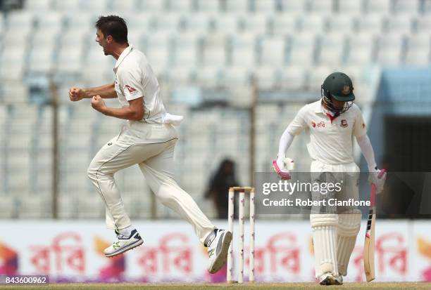 Pat Cummins of Australia celebrates after taking the wicket of Mushfiqur Rahim of Bangladesh during day four of the Second Test match between...