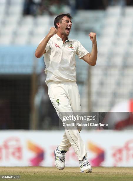 Pat Cummins of Australia celebrates after taking the wicket of Mushfiqur Rahim of Bangladesh during day four of the Second Test match between...