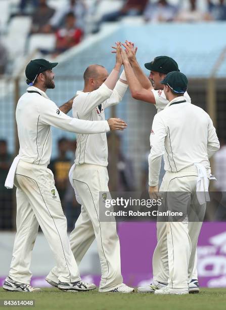 Nathan Lyon of Australia and Pat Cummins celebrate after they combined to dismiss Mominul Haque of Bangladesh during day four of the Second Test...