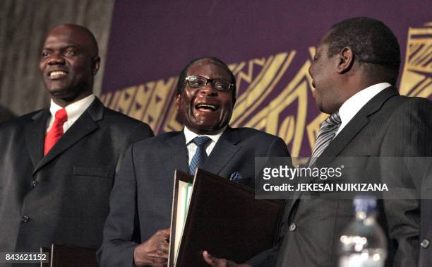 Zimbabwe's President Robert Mugabe laughs flnaked by Zimbabwean MDC breakaway faction leader Arthur Mutambara and Opposition's leader Morgan...