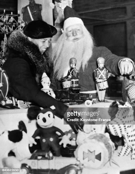 Madame Roosevelt, femme du Président américain, fait son choix de jouets sous le regard bienveillant du Père Noël, à Washington, Etats-Unis le 21...