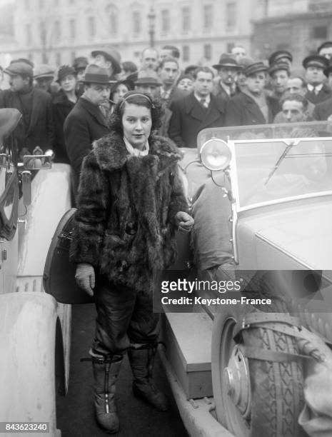 Une jeune femme, future participante au rallye automobile de Monte-Carlo, fait une escale devant l'Automobile Club le 22 janvier 1935 à Paris, France.