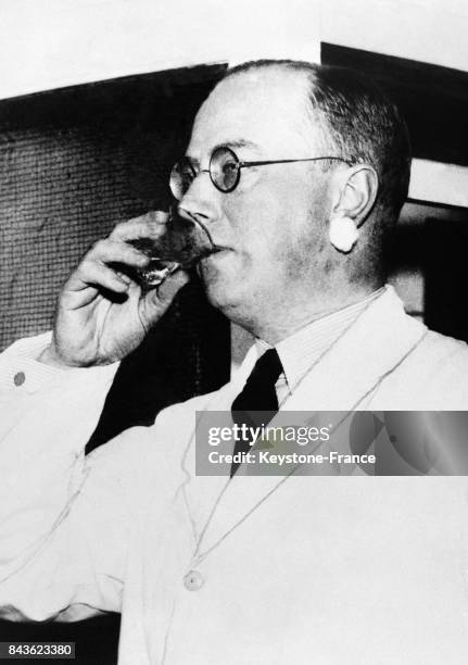 Le professeur norvégien Klaus Hansen boit un verre d'eau lourde, pourtant habituellement considérée comme un poison mortel le 18 février 1935 à Oslo,...