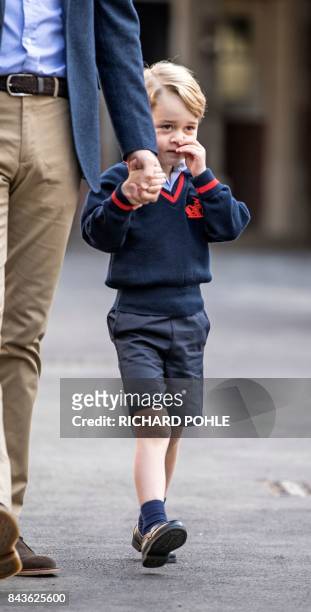 Britain's Prince George accompanied by Britain's Prince William , Duke of Cambridge arrives for his first day of school at Thomas's school in...