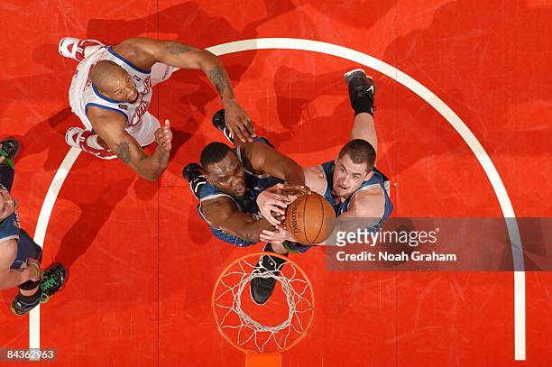 Al Jefferson and Kevin Love of the Minnesota Timberwolves reach for a loose ball against the Los Angeles Clippers at Staples Center on January 19,...