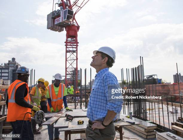 Real estate owner Eliot Spitzer looks at one of his nearly completed apartment buildings as employees of a construction company continue work on his...
