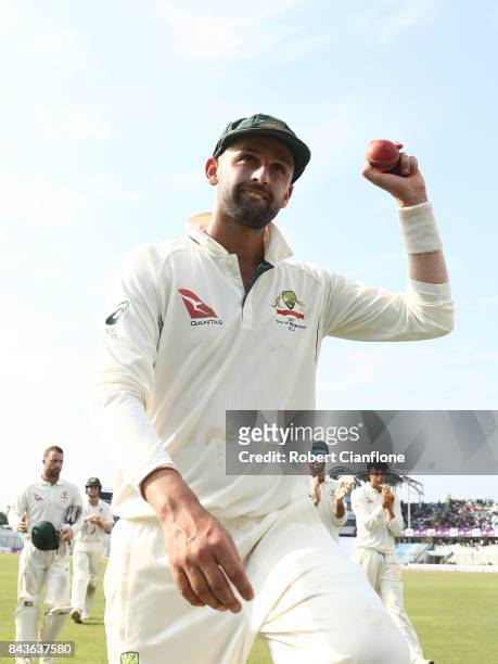 Nathan Lyon of Australia holds up the ball after he took 13 wickets for the match during day four of the Second Test match between Bangladesh and...