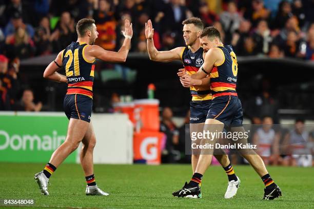 Brodie Smith of the Crows celebrates with Rory Atkins and Jake Kelly of the Crows after kicking a goal during the AFL First Qualifying Final match...