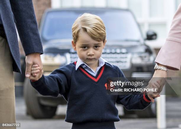 Britain's Prince George accompanied by Britain's Prince William , Duke of Cambridge arrives for his first day of school at Thomas's school where he...