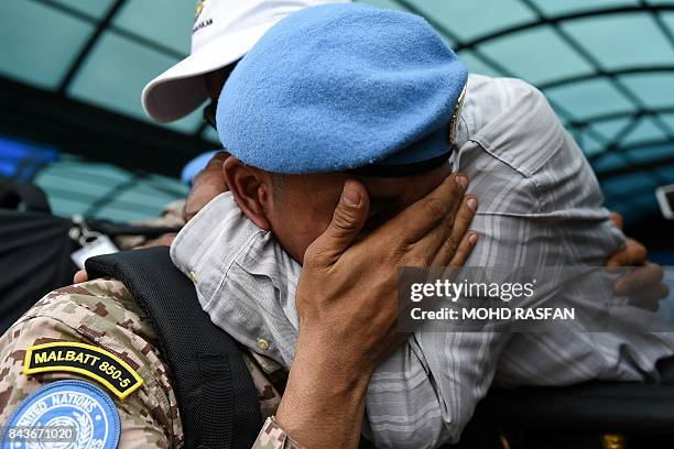 Muhammad Fariz a member of the Malaysian armed forces, hugs his father Ahmad Shukri before boarding a flight for the first batch of the Malaysian...