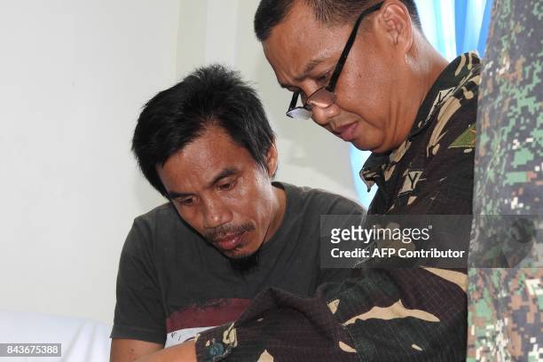 Indonesian national Sawal Maryam , who escaped after being kidnapped by the Abu Sayyaf group, is interviewed by a Philippine military officer at a...