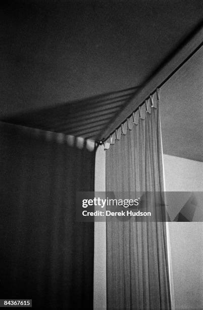 Light casting a shadow on the wall of a bedroom curtain and rail in the guest house Dar Nour, Tangier.