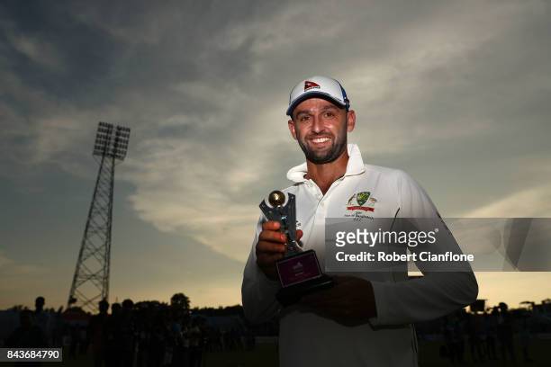 Nathan Lyon of Australia poses with the Man of the Match trophy after Australia defeated Bangladesh on day four of the Second Test match between...