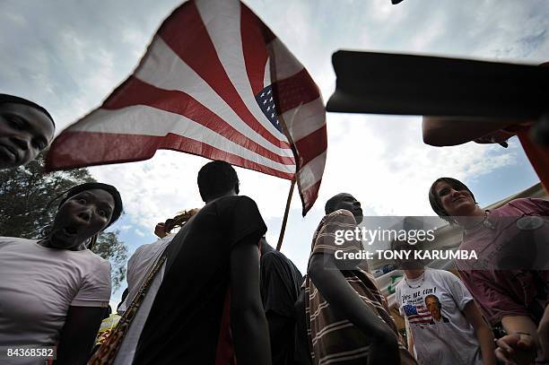 Australian tourists join villagers of Nyang'oma raising a US flag celebrating prior to the inauguration of US President Barack Obama on January 20,...