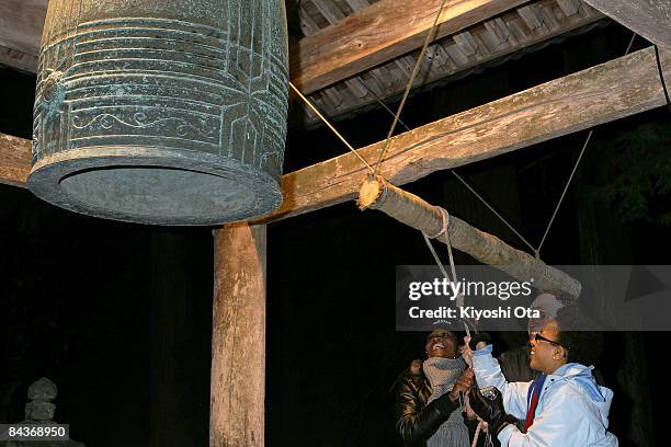 Alcillena Wilson of the United States, Felipe Vernaza of Canada and Ashley Hayes of the United States strike a bell to celebrate the inauguration of...