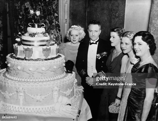 Près du grand gâteau d'anniversaire, de gauche à droite, Alice Faye, l'amiral Byrd, Betty Furness, Glenda Farrell et Sue Gomez, à Los Angeles,...