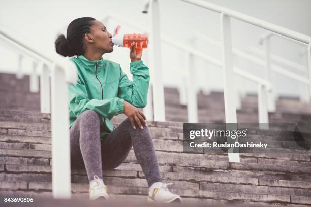 loper vrouw drinken gezuiverd water buitenshuis. - purified water stockfoto's en -beelden