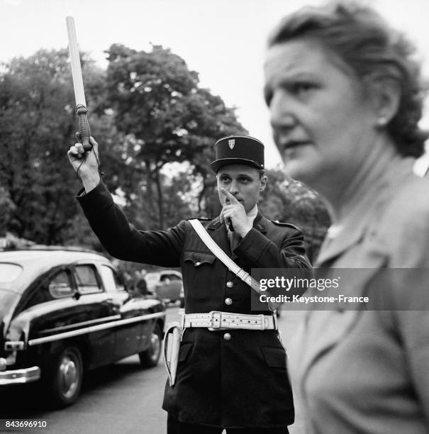 Agent de police faisant la circulation dans les rues de Paris, France en juillet 1954.