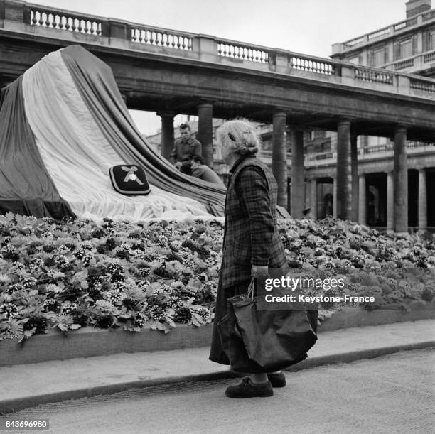Femme se recueillant lors des obsèques de la romancière Colette dans la cour d'honneur du palais royal, à Paris, France, le 7 août 1954.