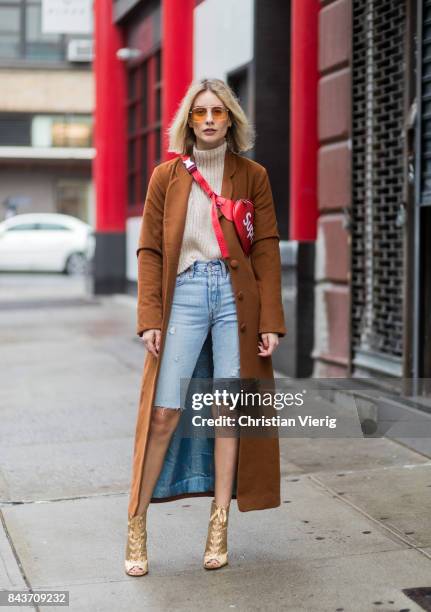 Lisa Hahnbueck wearing cropped denim shorts, red Supreme x Louis Vuitton bag, brown wool coat, golden heels, turtleneck on September 6, 2017 in New...