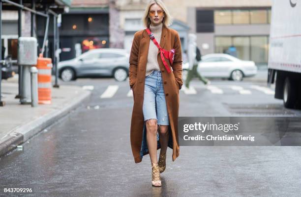 Lisa Hahnbueck wearing cropped denim shorts, red Supreme x Louis Vuitton bag, brown wool coat, golden heels, turtleneck on September 6, 2017 in New...