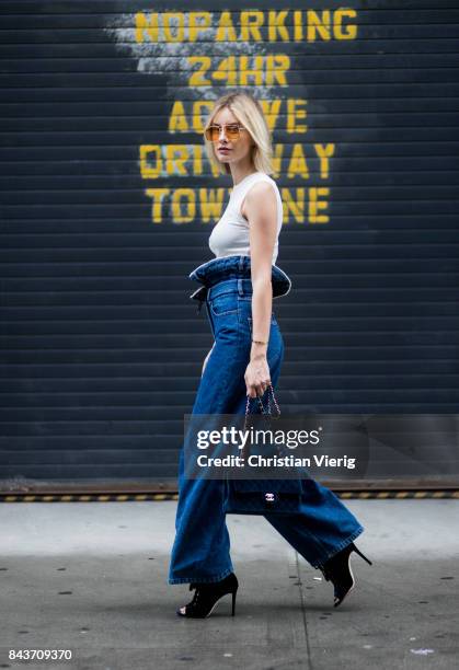 Lisa Hahnbueck wearing high waisted denim jeans, white tshirt, blue Chanel velvet bag on September 6, 2017 in New York City.