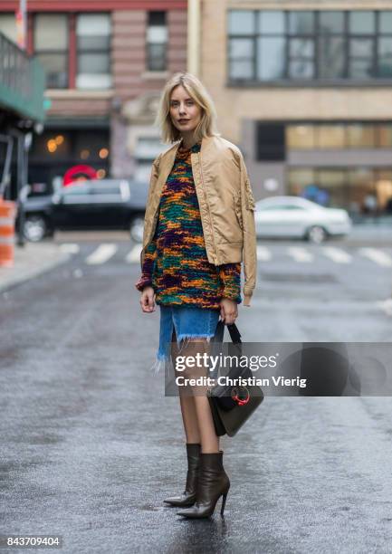Lisa Hahnbueck wearing wearing mustard bomber jacket, Missoni sweater, cutted denim skirt, JW Anderson bag, ankle boots on September 6, 2017 in New...