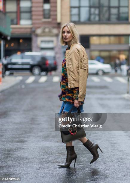 Lisa Hahnbueck wearing wearing mustard bomber jacket, Missoni sweater, cutted denim skirt, JW Anderson bag, ankle boots on September 6, 2017 in New...