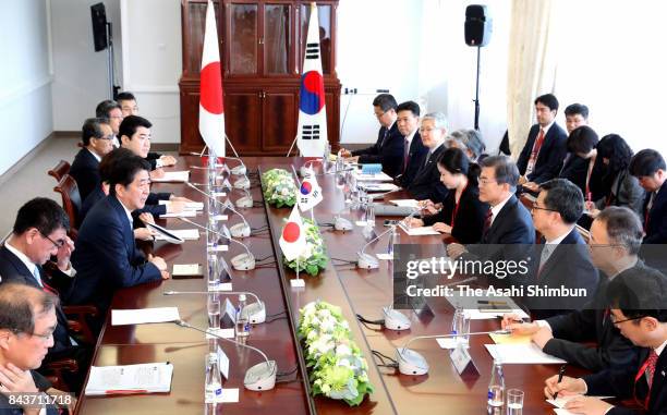 Japanese Prime Minister Shinzo Abe and South Korean President Moon Jae-in talk during their bilateral meeting on the sidelines of the Eastern...