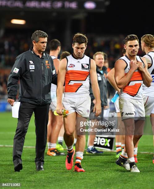 Giants head coach Leon Cameron and Toby Greene of the Giants walk from the ground looking dejected after being defeated by the Adelaide Crows during...