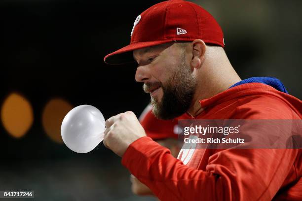Cameron Rupp of the Philadelphia Phillies blows a bubble in the dugout during a game against the New York Mets at Citi Field on September 5, 2017 in...