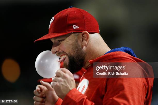 Cameron Rupp of the Philadelphia Phillies blows a bubble in the dugout during a game against the New York Mets at Citi Field on September 5, 2017 in...