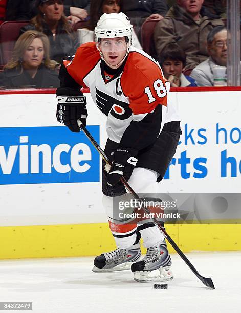 Mike Richards of the Philadelphia Flyers skates up ice with the puck during the game against the Vancouver Canucks at General Motors Place on...