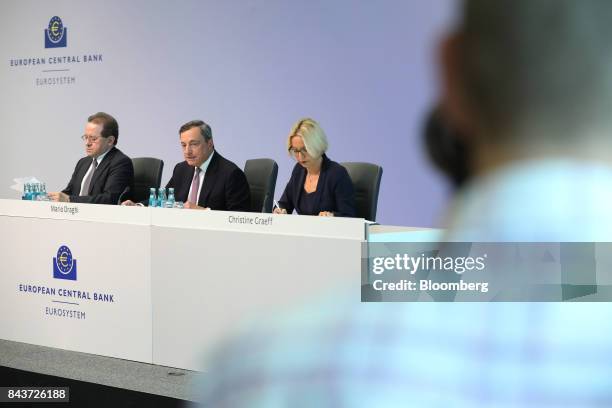 Mario Draghi, president of the European Central Bank , center, speaks as he sits between Vitor Constancio, vice president of the European Central...