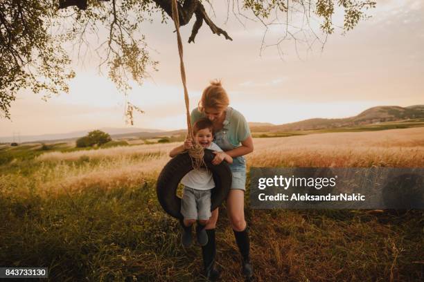 motherhood - tire swing stock pictures, royalty-free photos & images