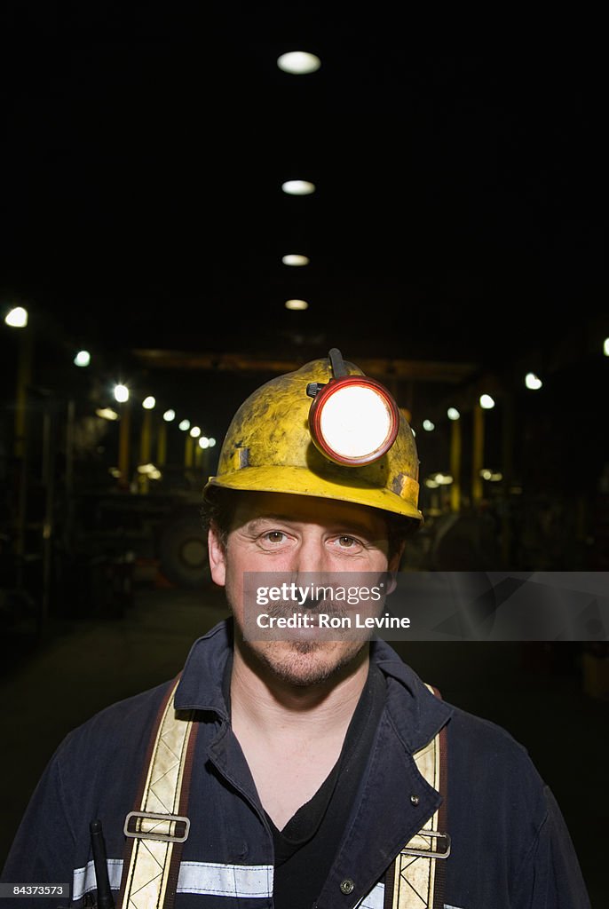 Zinc miner in heavy vehicle repair shop, portrait