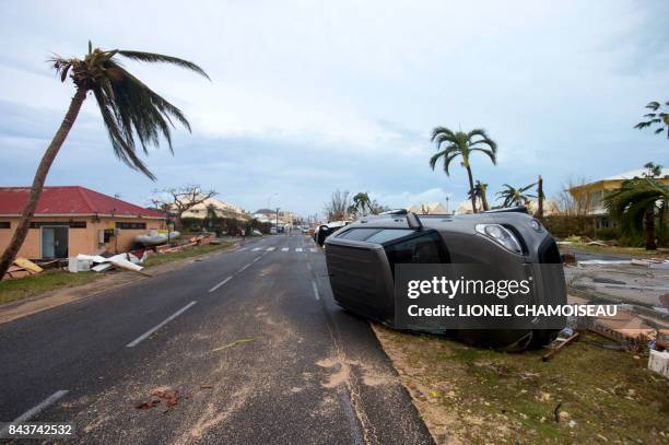 Photo taken on September 6, 2017 shows a car turned onto its side in Marigot, near the Bay of Nettle, on the French Collectivity of Saint Martin,...