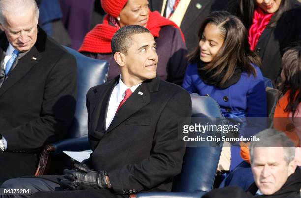 President-elect Barack Obama looks back during his inauguration as his daughter Malia looks on January 20, 2009 in Washington, DC. Obama becomes the...