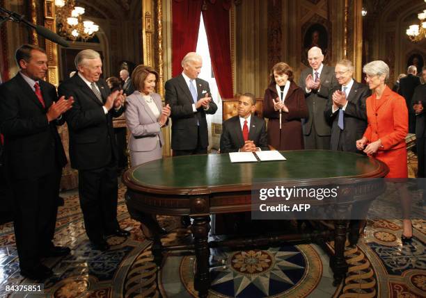 President Barack Obama signs one of his first acts as President infront of members of the Joint Congressional Committee on Inaugural Ceremonies House...