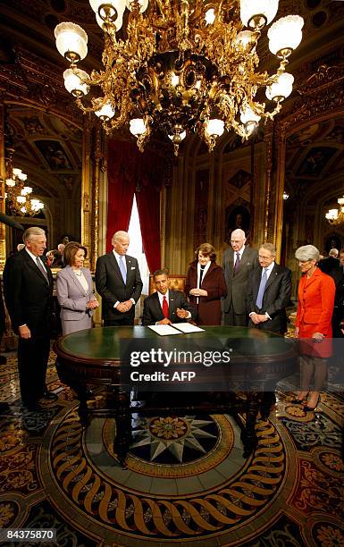 President Barack Obama signs one of his first acts as President infront of members of the Joint Congressional Committee on Inaugural Ceremonies House...