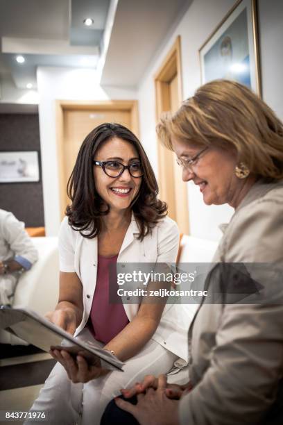 femme âgée au docteur - médecin content photos et images de collection