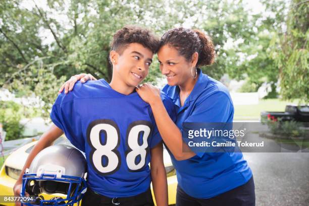 mother supporting her teen before a football game - american football uniform stock pictures, royalty-free photos & images