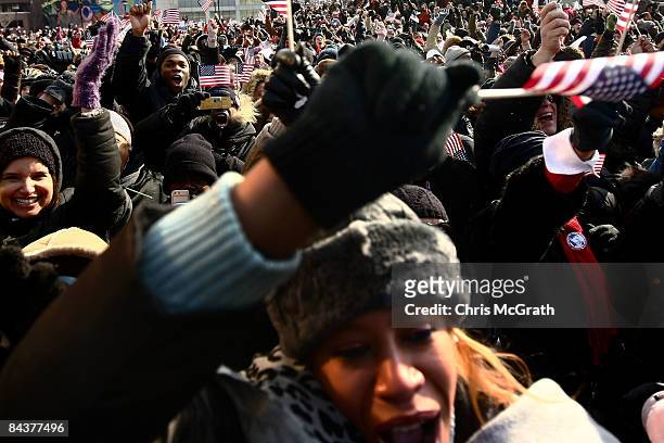 Large crowd celebrates while watching the inauguration of Barack Obama as the 44th president of the United States on a large screen in the...