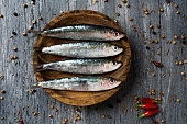 raw sardines on a rustic wooden table