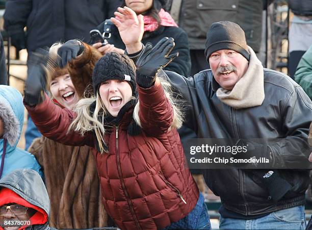 Spectators wave as US President Barack Obama and first lady Michelle Obama arrive at the Presidential Reviewing Stand during the Inaugural Parade...