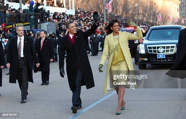 President Barack Obama and first lady Michelle Obama wave as they walk in the inaugural parade following his inauguration as the 44th President of...