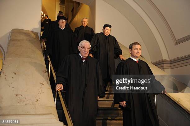 In this handout photo provided by the U.S. Air Force, U.S. Supreme Court Justice John Paul Stevens and Chief Justice John Roberts with other members...