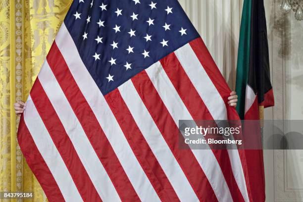 Marine adjusts the American flag ahead of a news conference with U.S. President Donald Trump and Sheikh Sabah Al-Ahmed Al-Sabah, Kuwait's emir, not...
