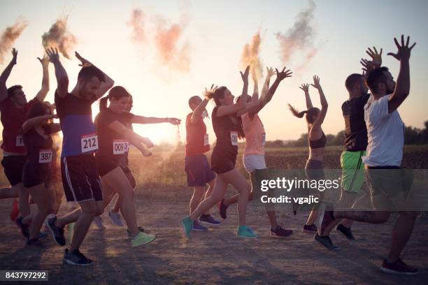 marathon racer werfen holi farben - holirun stock-fotos und bilder