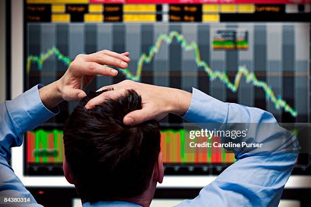 trader watching stocks crash on screen - mercado bursátil fotografías e imágenes de stock